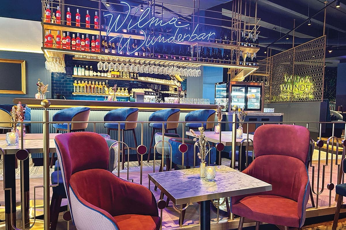 Inside Wilma Wunder in Nuremberg: velvet chairs and marble tables in front of the Wilma Wunderbar